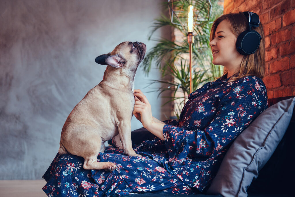 Mulher com cachorro atento ao seu redor em casa